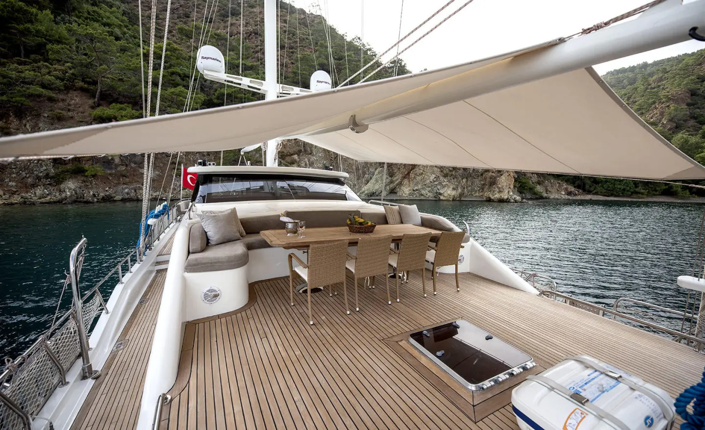 Kayhan 3 yacht deck lounge area with wooden floor and seating under canopy