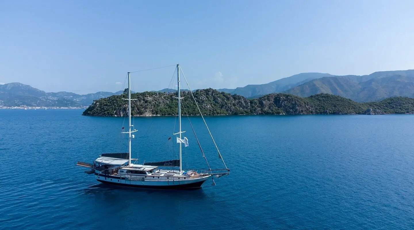 Blue sea with a sailing gulet anchored, seen from side