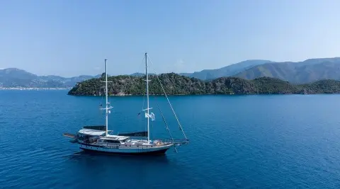 Blue sea with a sailing gulet anchored, seen from side