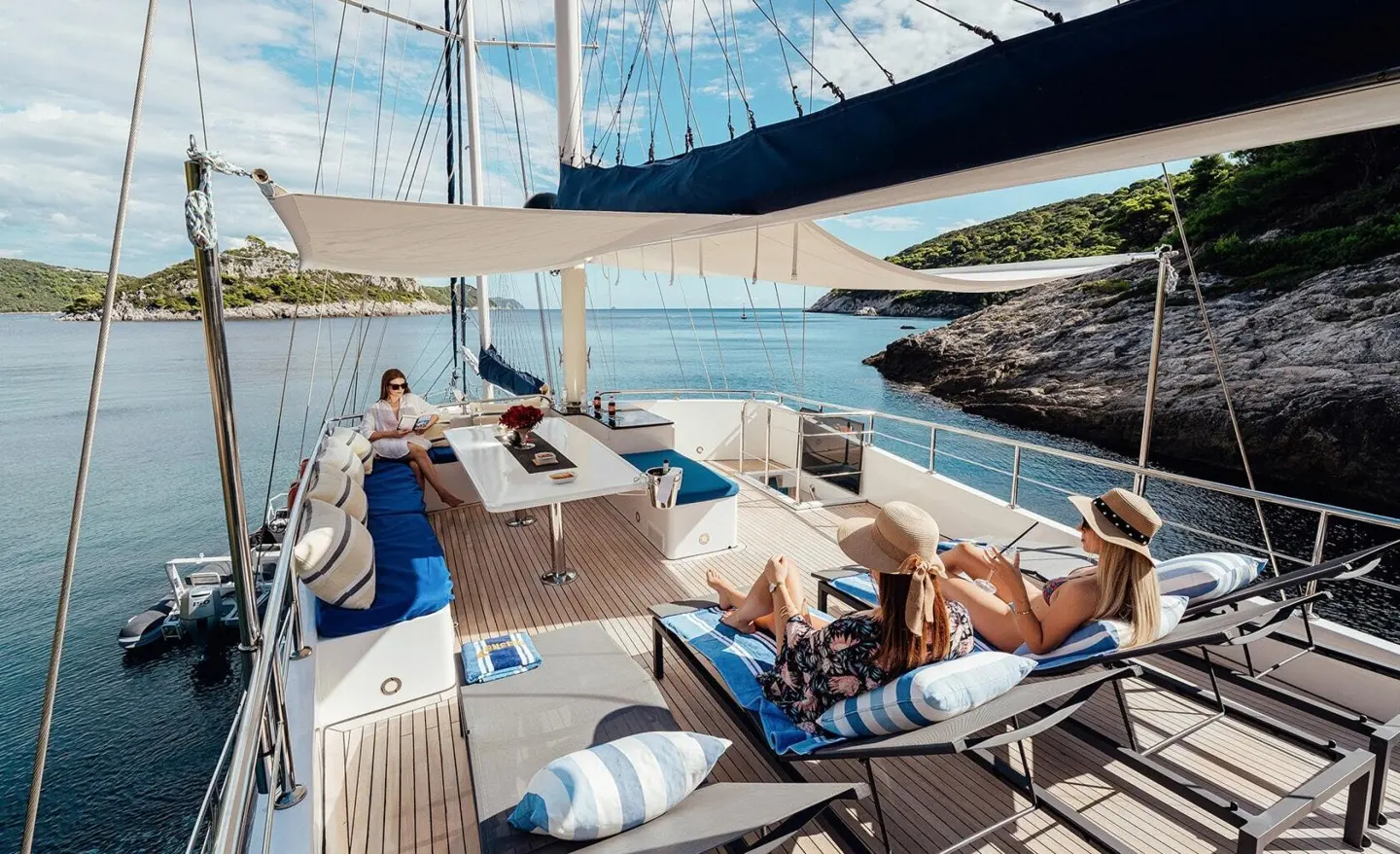 Maske yacht charter on a sunlit deck with loungers and blue sea backdrop