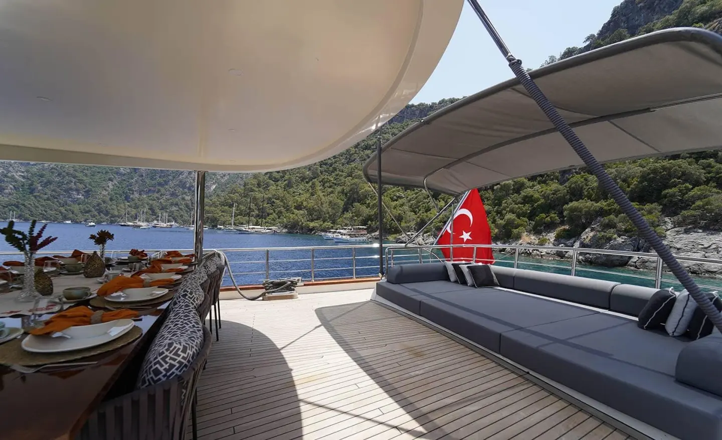 Queen Of Makri yacht deck at sunset with seating area and red lifebuoy