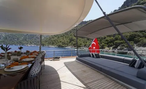 Queen Of Makri yacht deck at sunset with seating area and red lifebuoy
