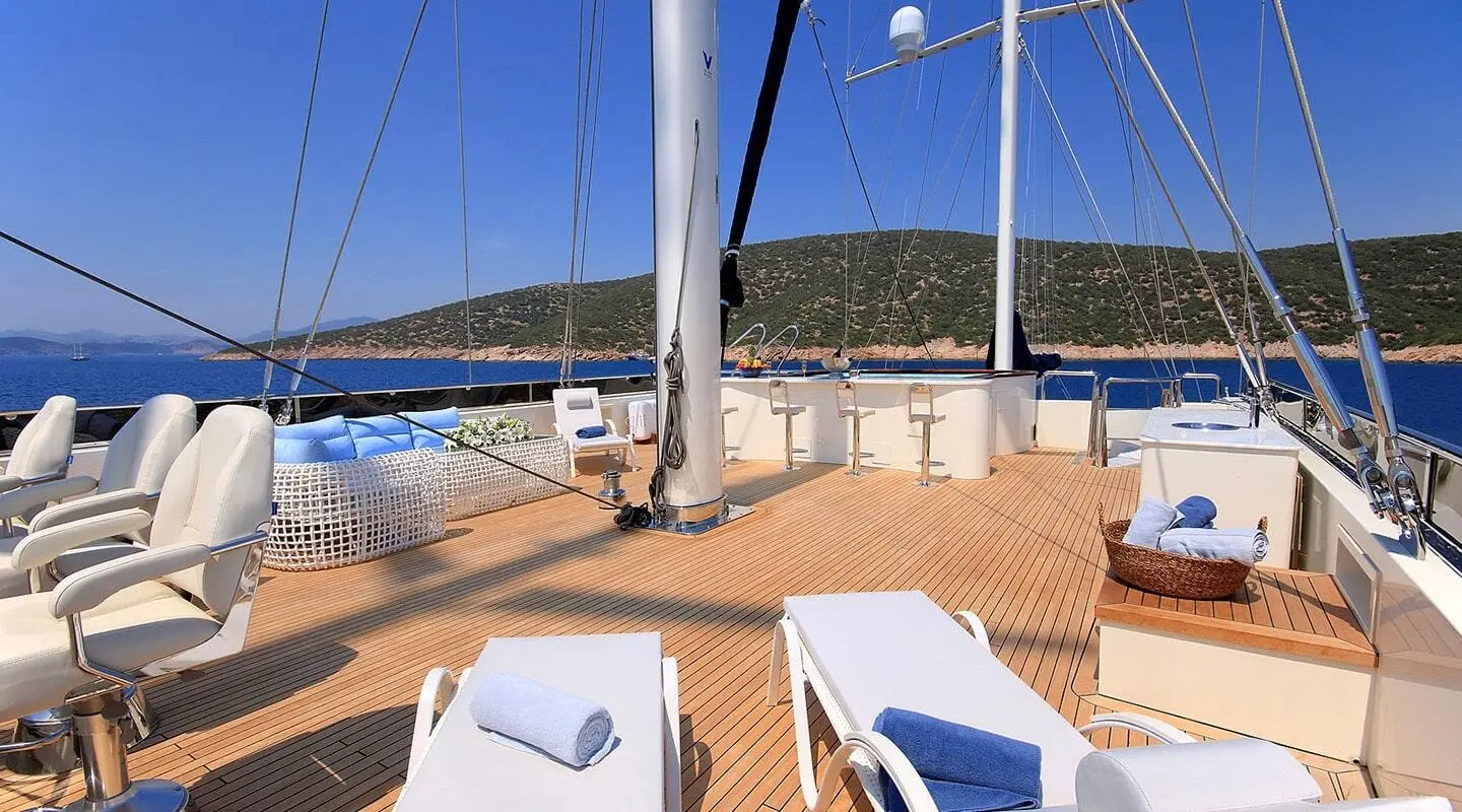 Meira yacht deck with sun loungers, ropes, and blue sea in background