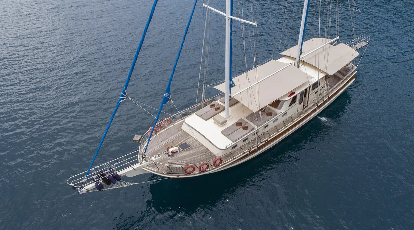 A luxury gulet yacht named Faralya anchored in calm blue water at sunset