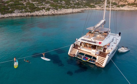 Serenissima yacht anchored with a large deck and turquoise water