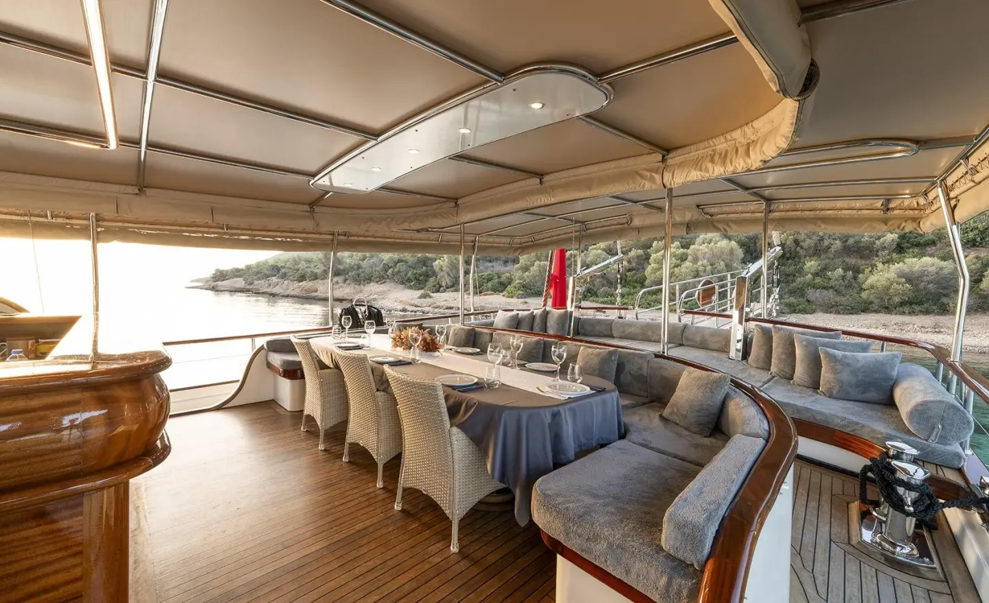 Open aft deck with dining table and seating on luxury yacht