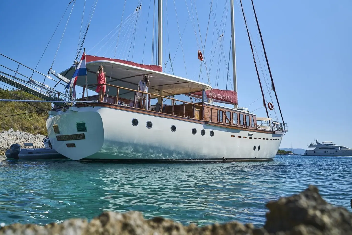 Morning Star luxury gulet with white hull anchored near rocky shore at sunset