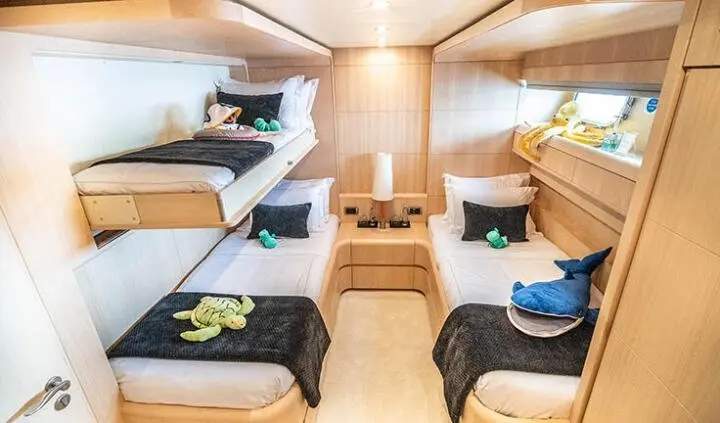 Pareaki II cabin with two twin bunk beds, navy linens, and wooden walls