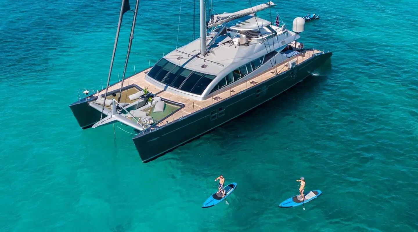 Cartouche yacht on turquoise water with terrace seating on deck