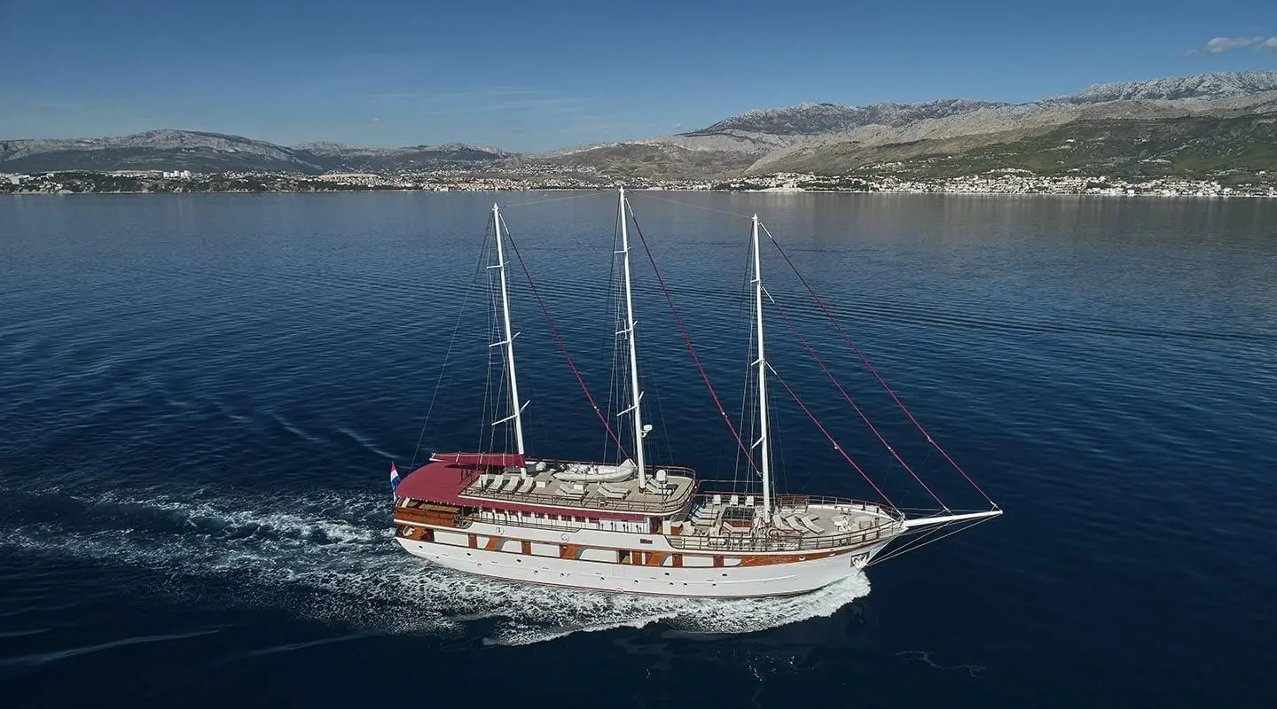Amorena yacht, three-masted luxury motor yacht sailing on blue sea, aerial view