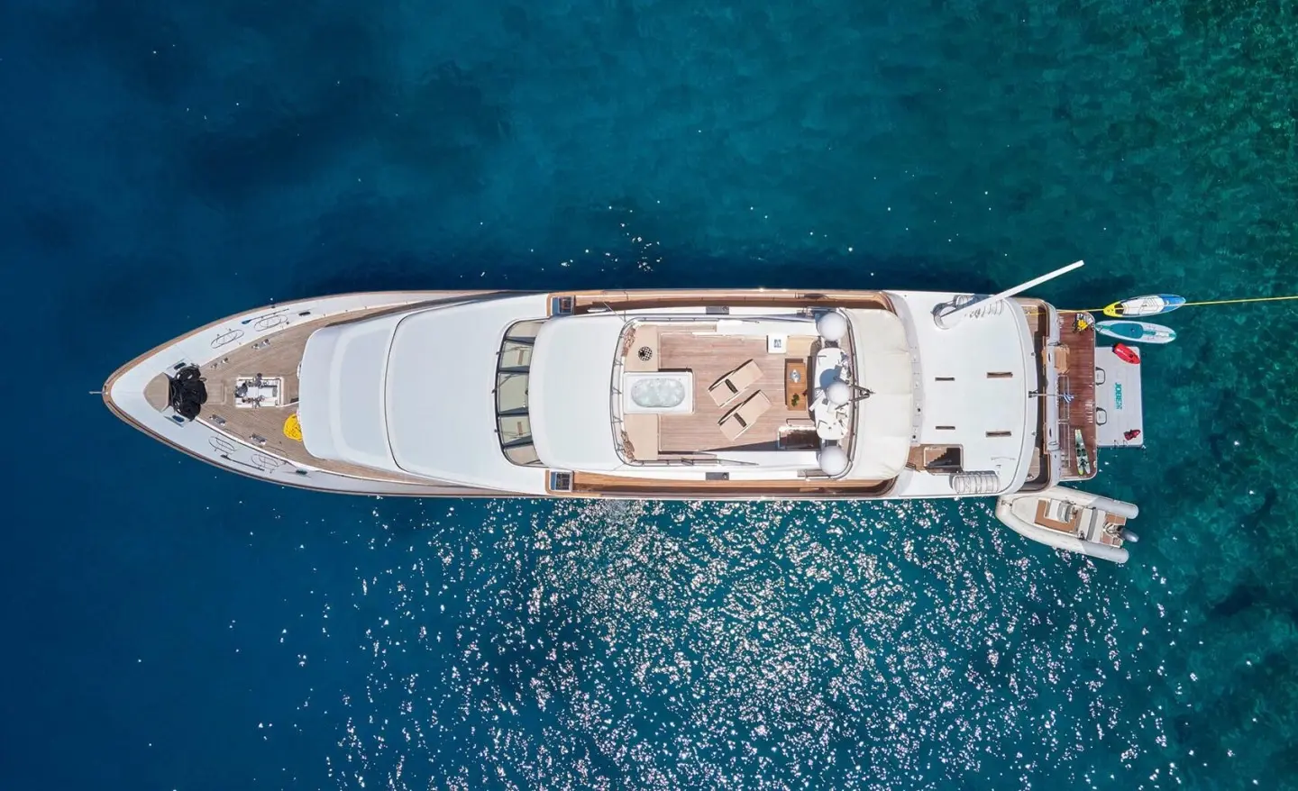 Overhead view of Idylle luxury yacht anchored in clear blue water at sunset