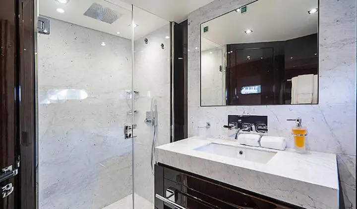 Quantum yacht cabin interior with marble surfaces, glass shower, and sleek vanity