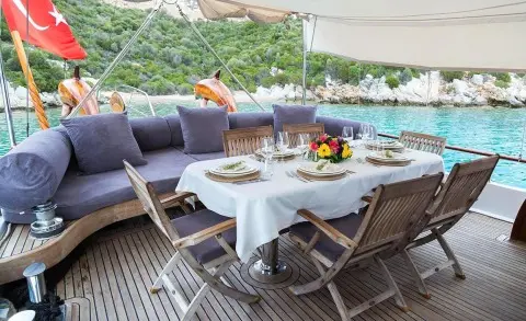 Primadonna gulet dining area on aft deck with table set and chairs