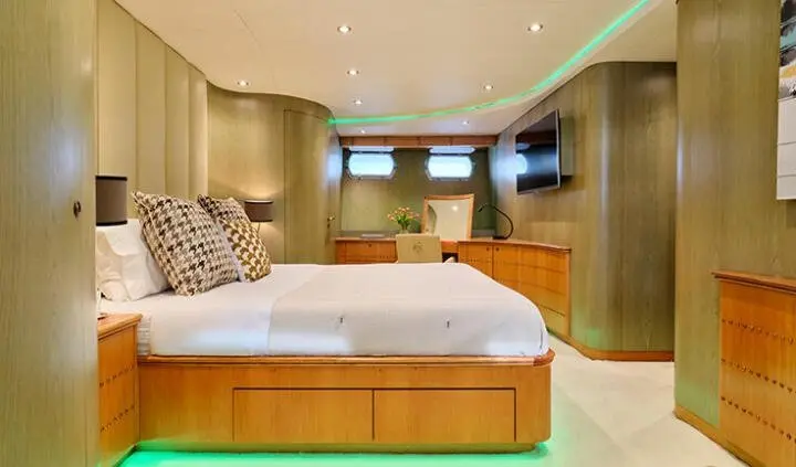 Mobius yacht cabin with king bed, white bedding, wood accents, ensuite visible