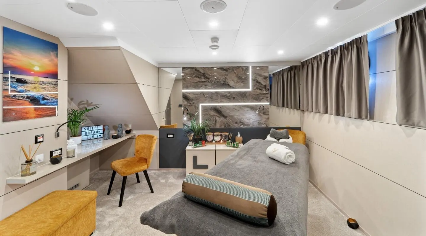 Luxurious yacht Freedom master bedroom with bed, seating, and elegant lighting
