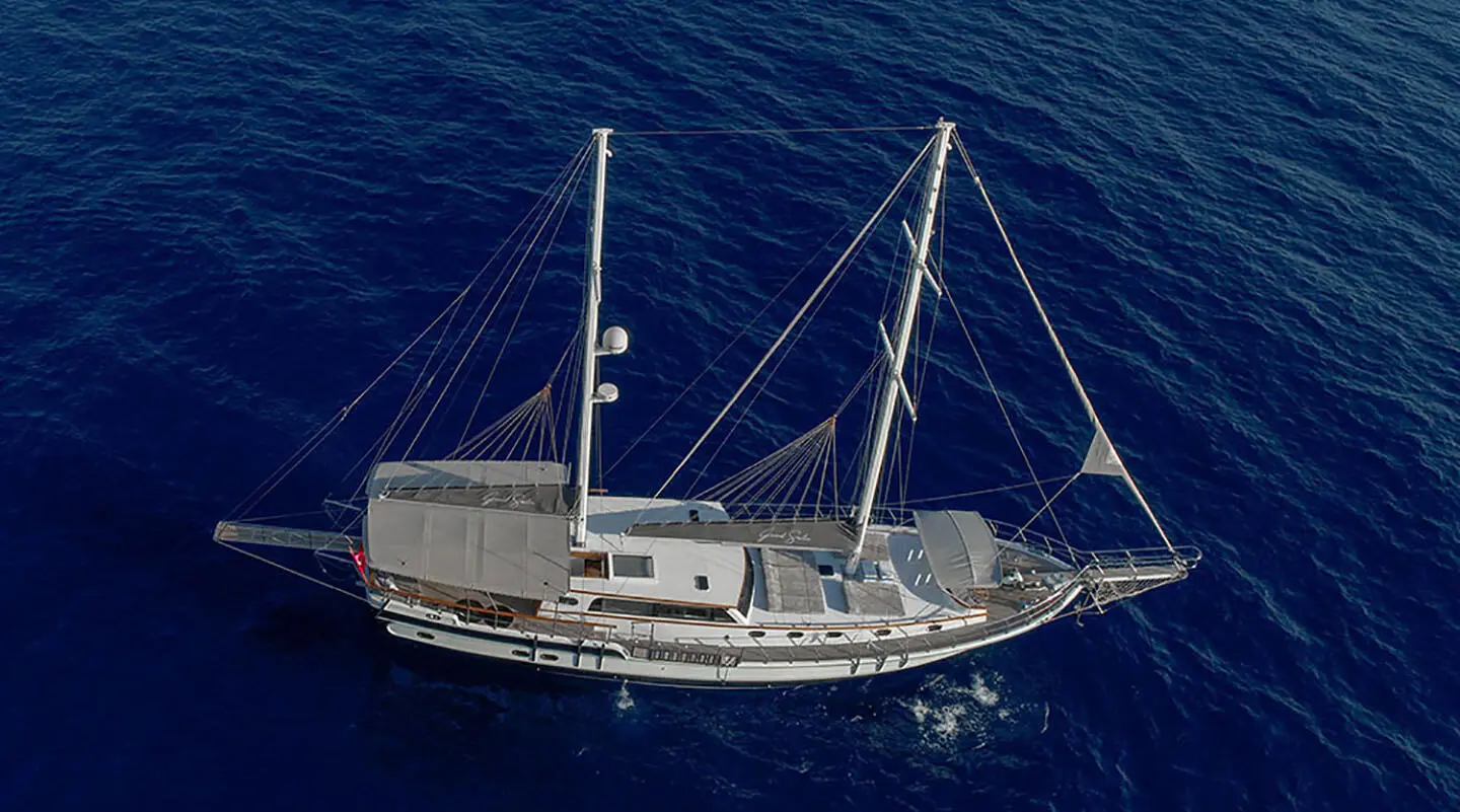 Luxury sailing yacht Grand Sailor anchored in calm blue sea at sunset