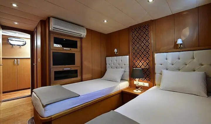 Blu Dream cabin interior with two single beds, wood panels, shelves
