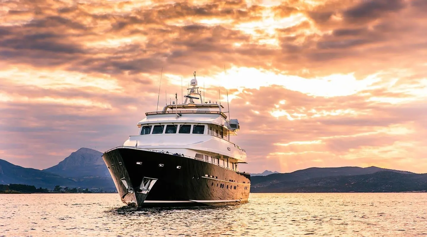 Magix luxury yacht anchored at sunset with calm sea and warm sky