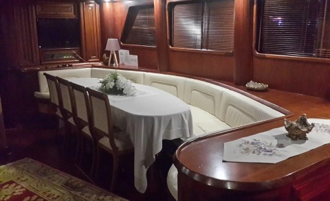 Inside wood-paneled lounge with white upholstered seating around a long table with a floral centerpiece