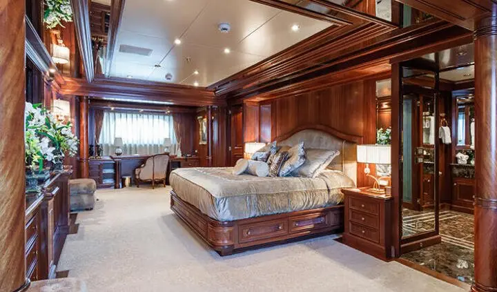 Master cabin with king bed, plush headboard, wood paneling, ensuite door