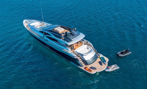 Above the large luxury motor yacht with lounge seating on the forward deck in open sea