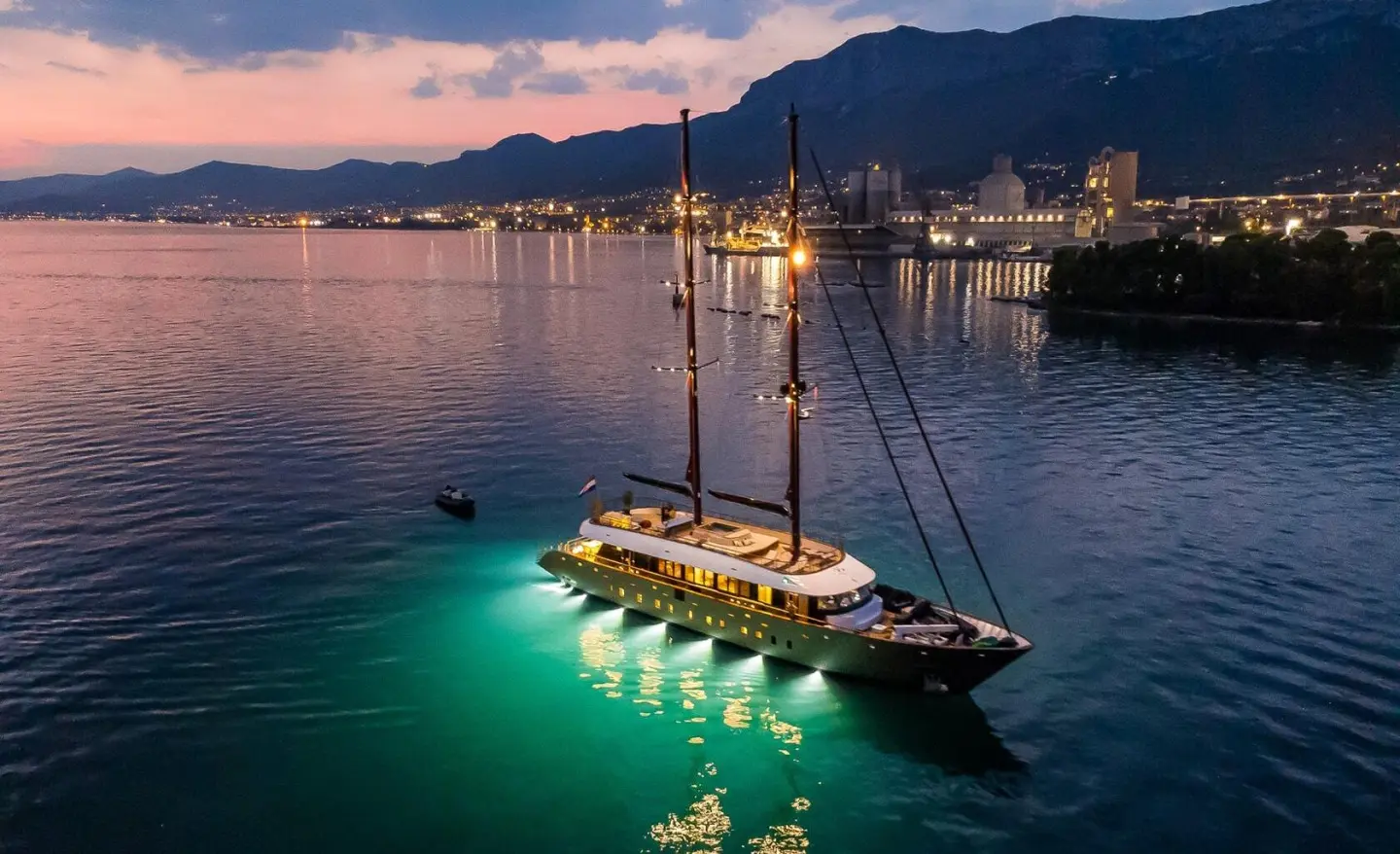 Evening view of luxury sailing yacht Anetta anchored near coast at sunset, calm water