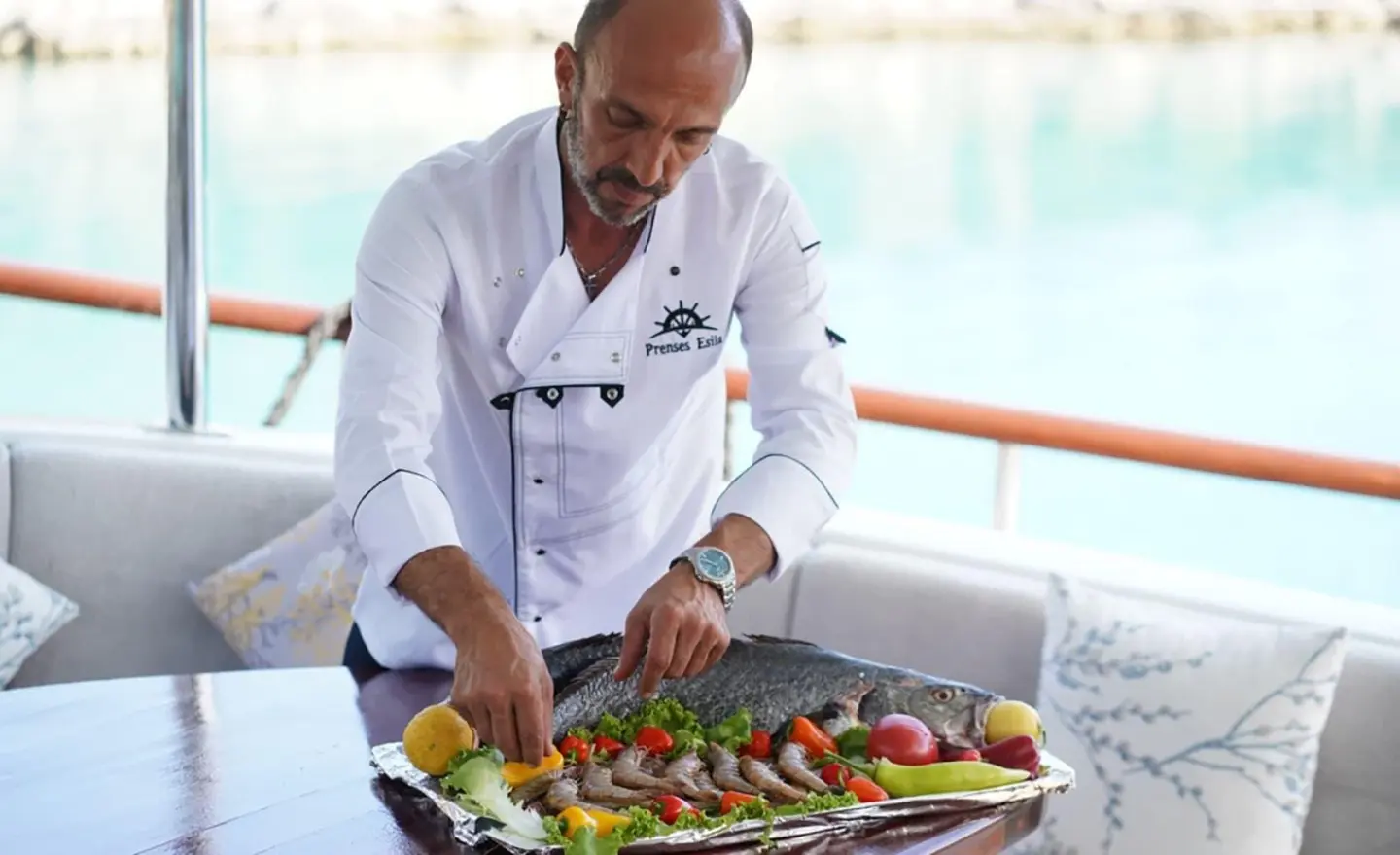 Prenses Esila yacht on calm sea with sunset glow and guests dining onboard