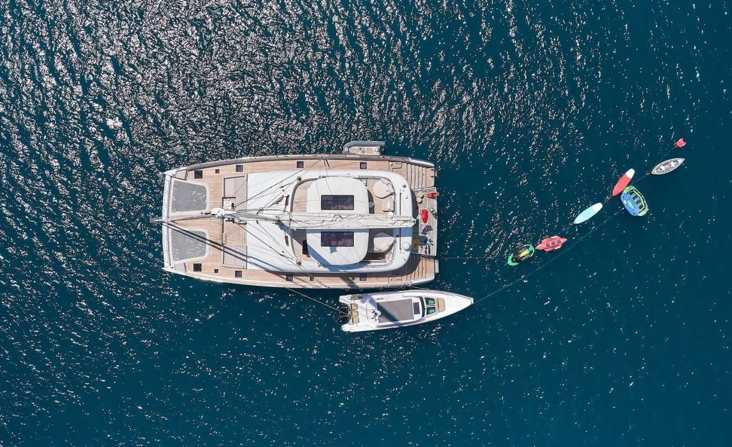 Aerial view of a gulet named Genny with white deck anchored near a small boat