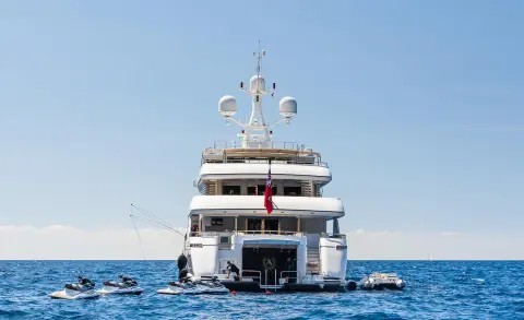 Apogee yacht docked, rear view on calm blue sea with clear sky
