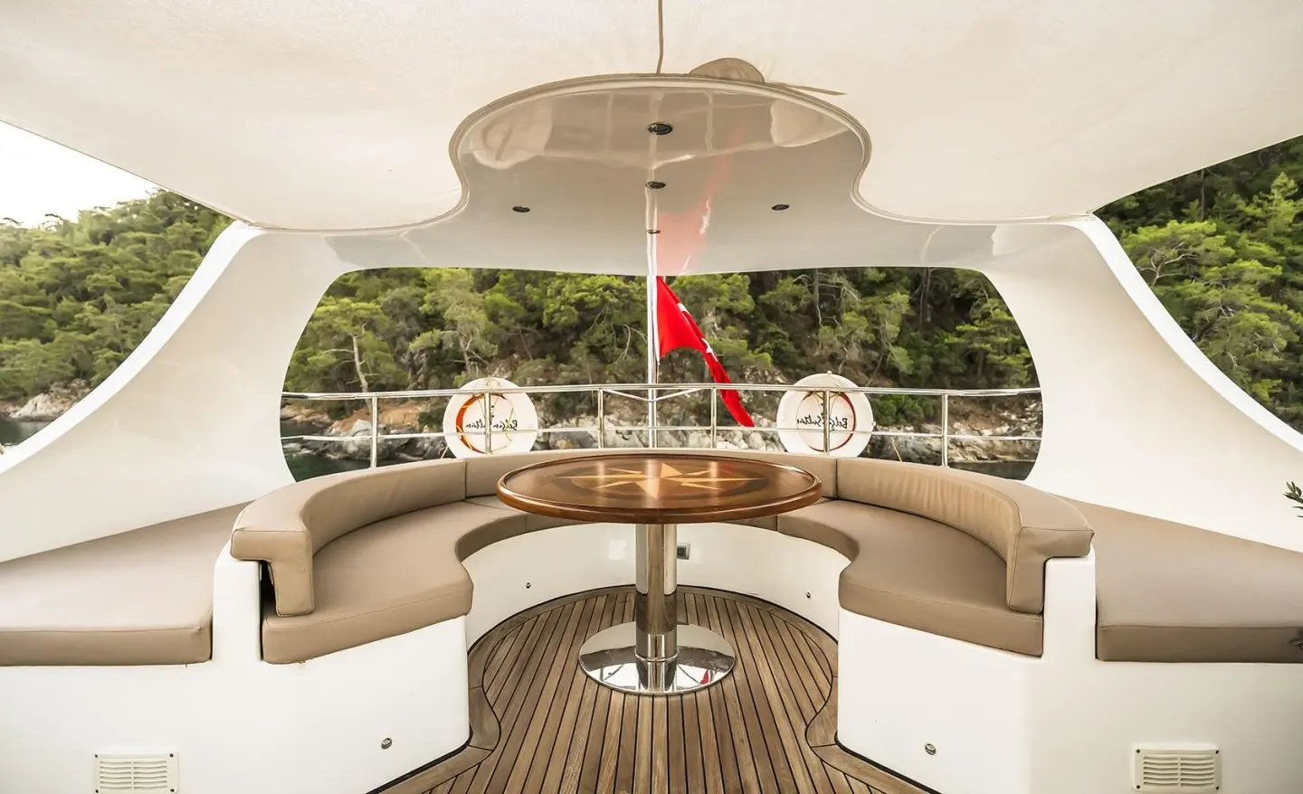 A luxurious forward cockpit on Belgin Sultan yacht at sunset, cushioned seating