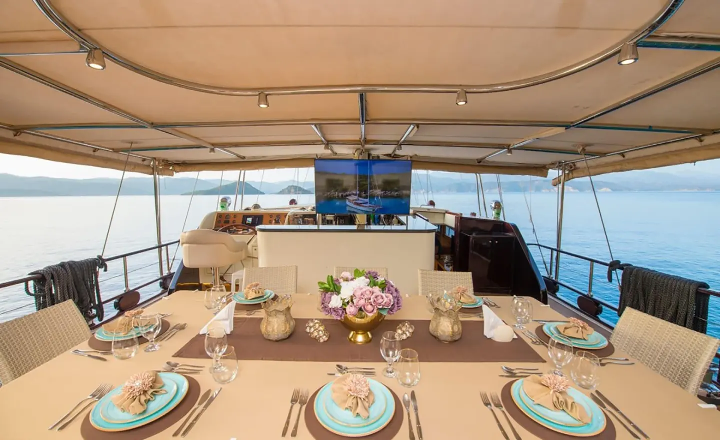 Yacht Mein Schatz dining deck setup at sunset with tableware and seating