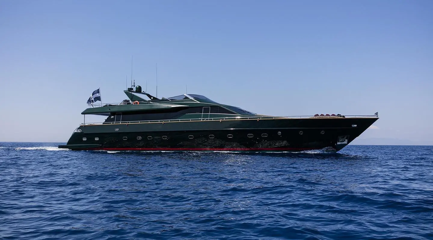 Side view of a dark yacht named Can't Remember docked on calm blue water