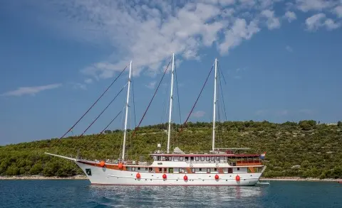 Side view of Amorena motor yacht with white hull and red accents near shore