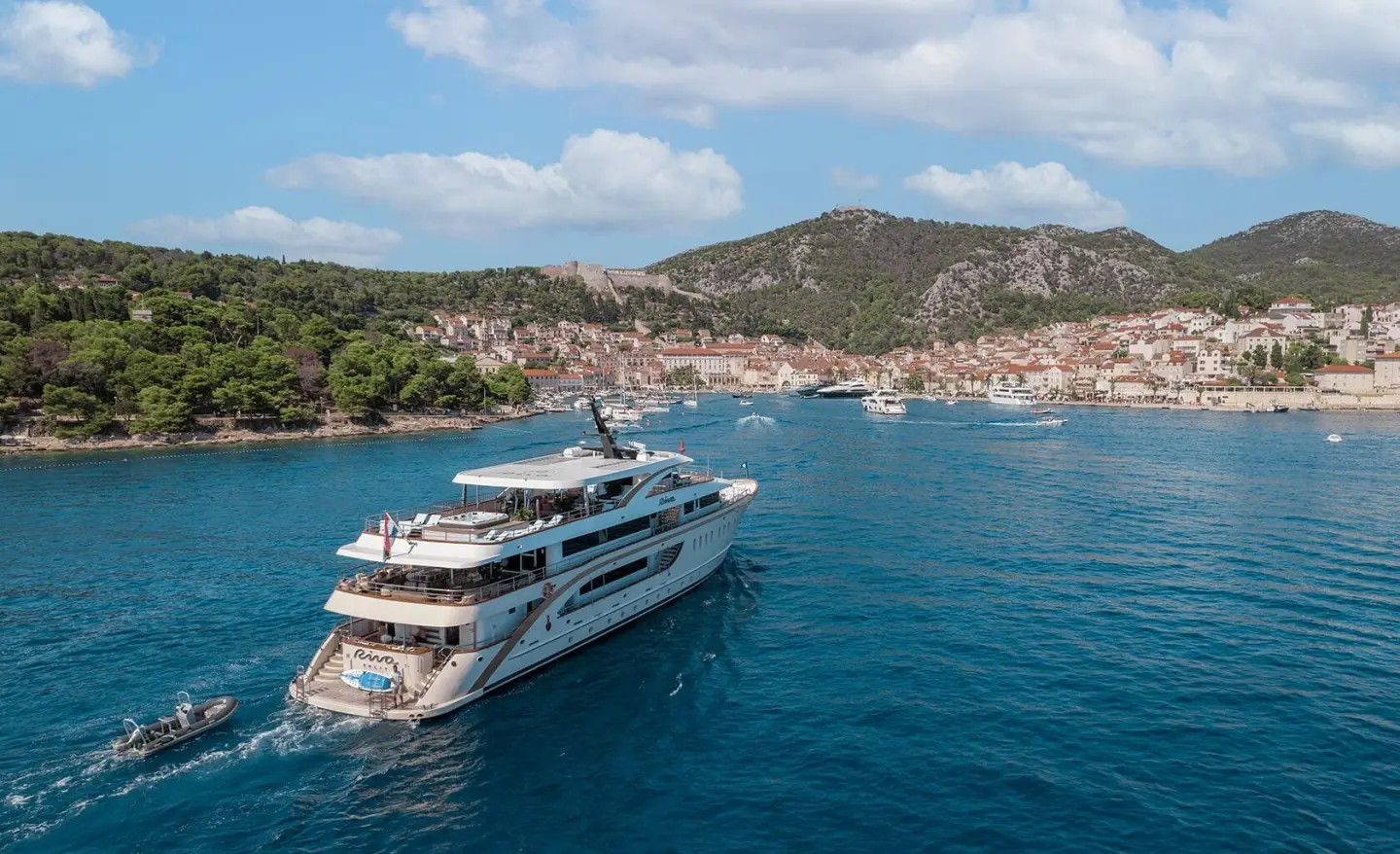 Riva motor yacht sailing near a town with shoreline