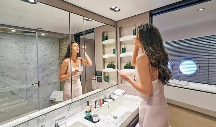 Aluminia Too master cabin with a king bed and ensuite bathroom seen in mirror view
