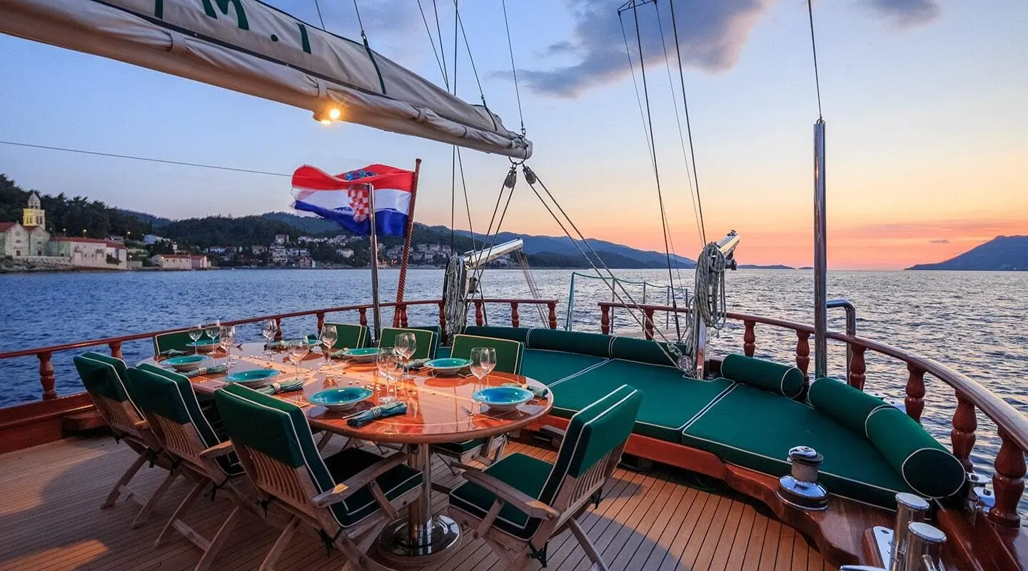 Carpe Diem 7 yacht deck at sunset with dining table set for guests