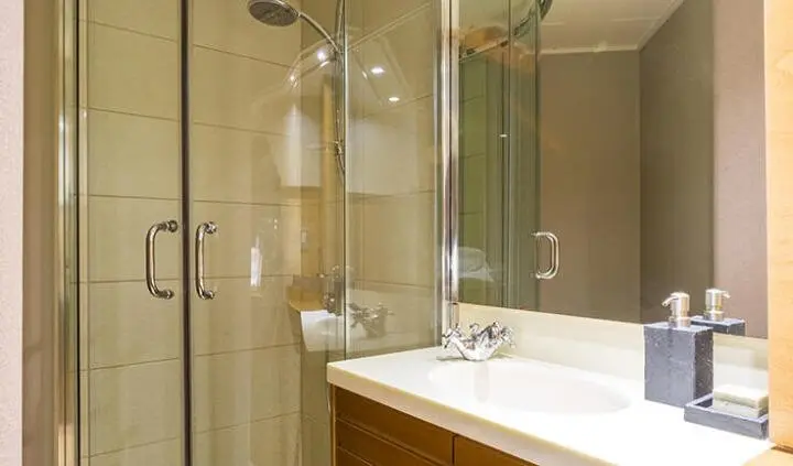 Yacht Aquarella cabin bathroom with beige-tiled walls and glass shower