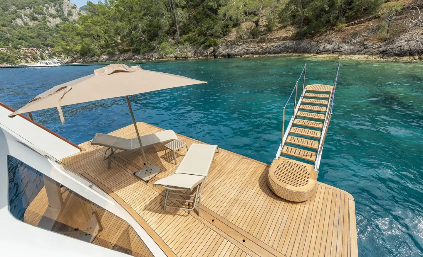 Open deck with sun lounger, umbrella and clear sea water