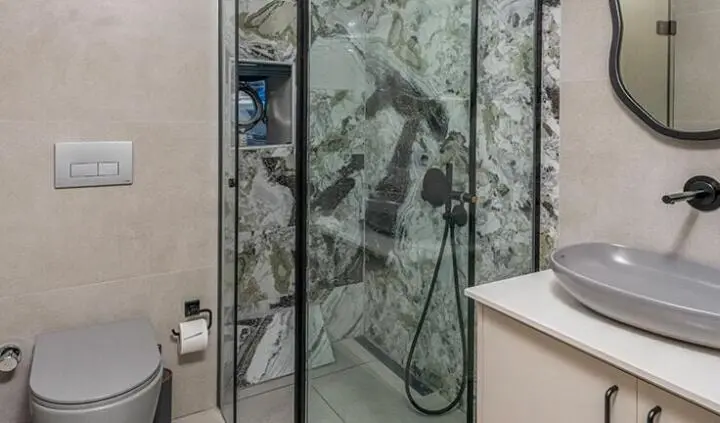 Glass door to a marble ensuite shower on Calm Down yacht cabin interior