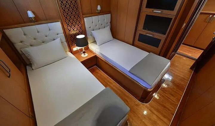 Blu Dream cabin interior with blue sofa-style bed and wooden cabinetry