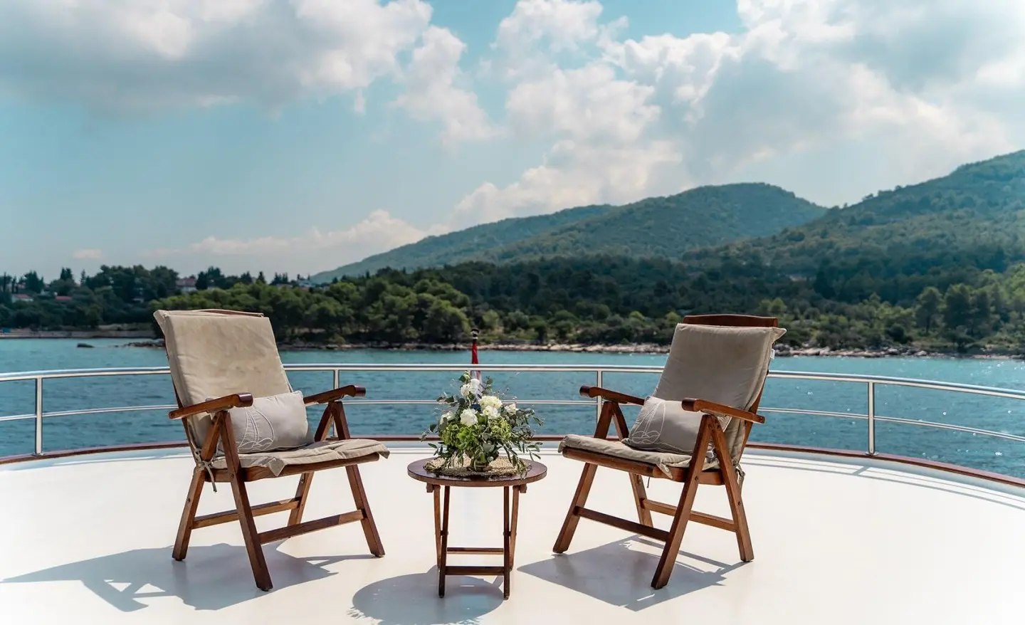 Cesarica yacht sailside deck with two chairs and small table overlooking blue sea