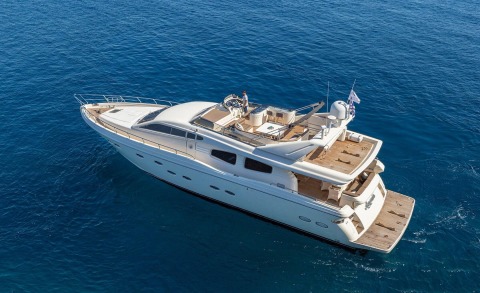 Amoraki motor yacht photographed from above with white exterior and open seating area on the deck over blue sea