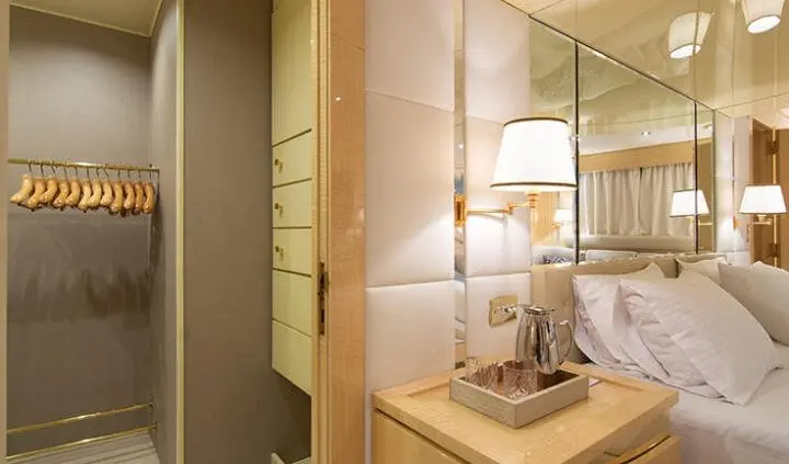 Luxurious master cabin with king bed, framed panels, and bedside lamps
