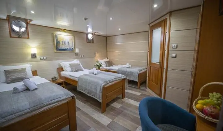 Triple-cabin yacht Karizma interior with three beds and wooden decor