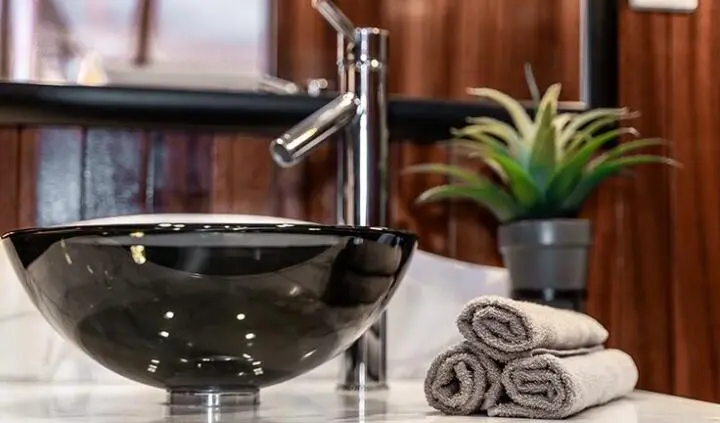 Cesarica cabin bathroom sink with faucet, mirror, and rolled towels visible