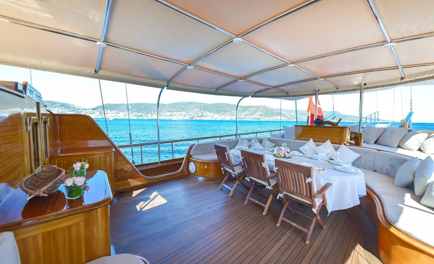 Lady Christa's teak deck dining area aboard a luxury yacht with a canopy and sea view