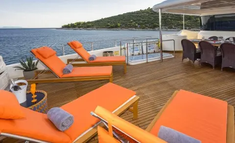 Seventh Sense yacht sun deck with orange loungers and ocean view