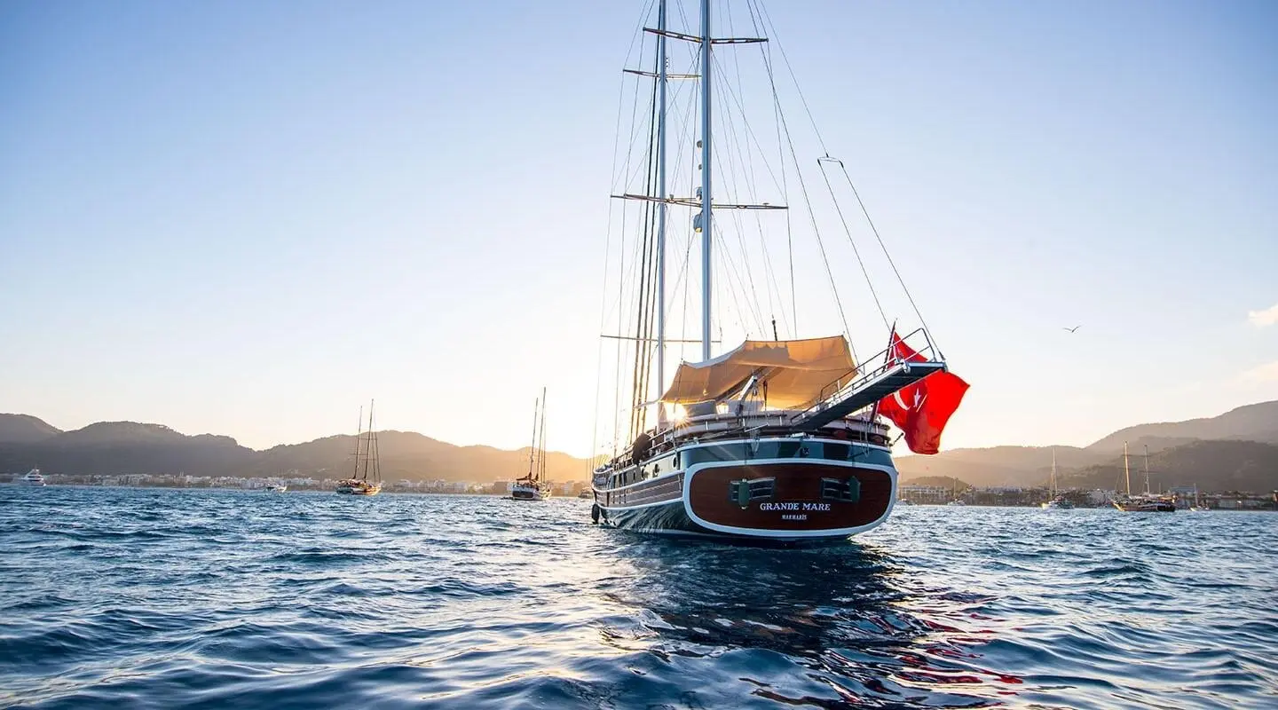 Grande Mare yacht anchored on calm sea at sunset with sailboat behind