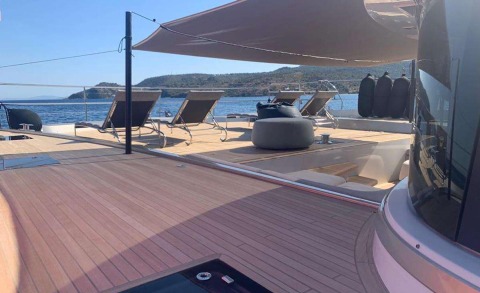 Just Marie 2 yacht on a sun deck with lounge chairs and shaded area on a wooden deck