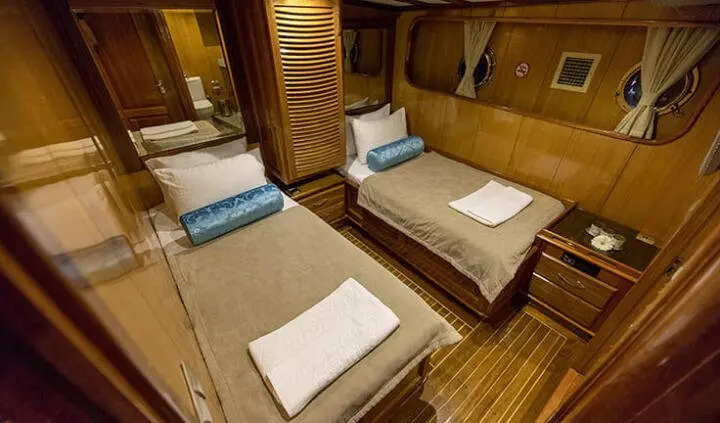 Twin cabin ensuite aboard Kayhan 5 yacht with two single beds and wooden paneling